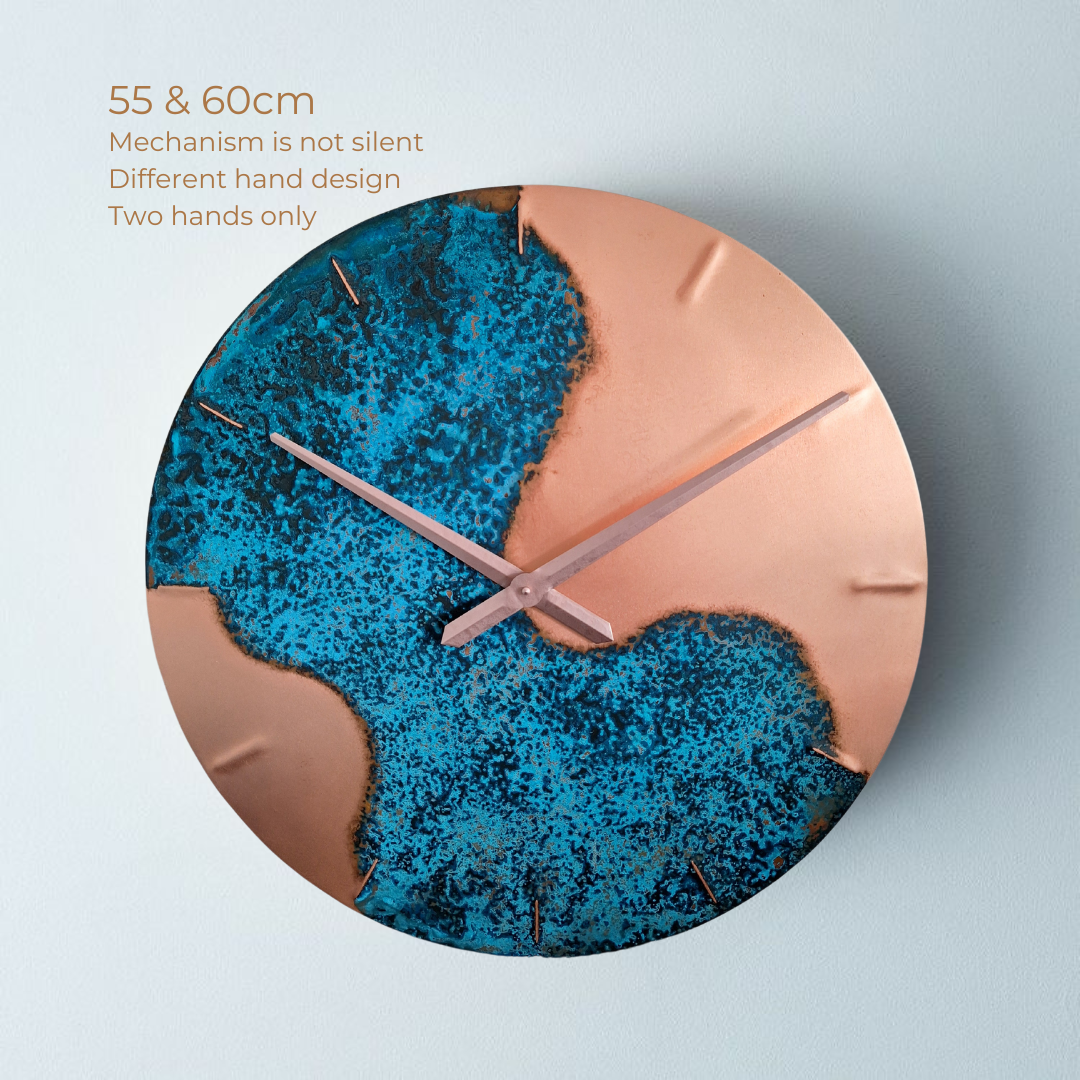 A large, round, blue patina, copper “half time” wall clock made by Empire Copper on a light grey background. With text on the image that explains larger sized clocks do not have a silent mechanism. 
